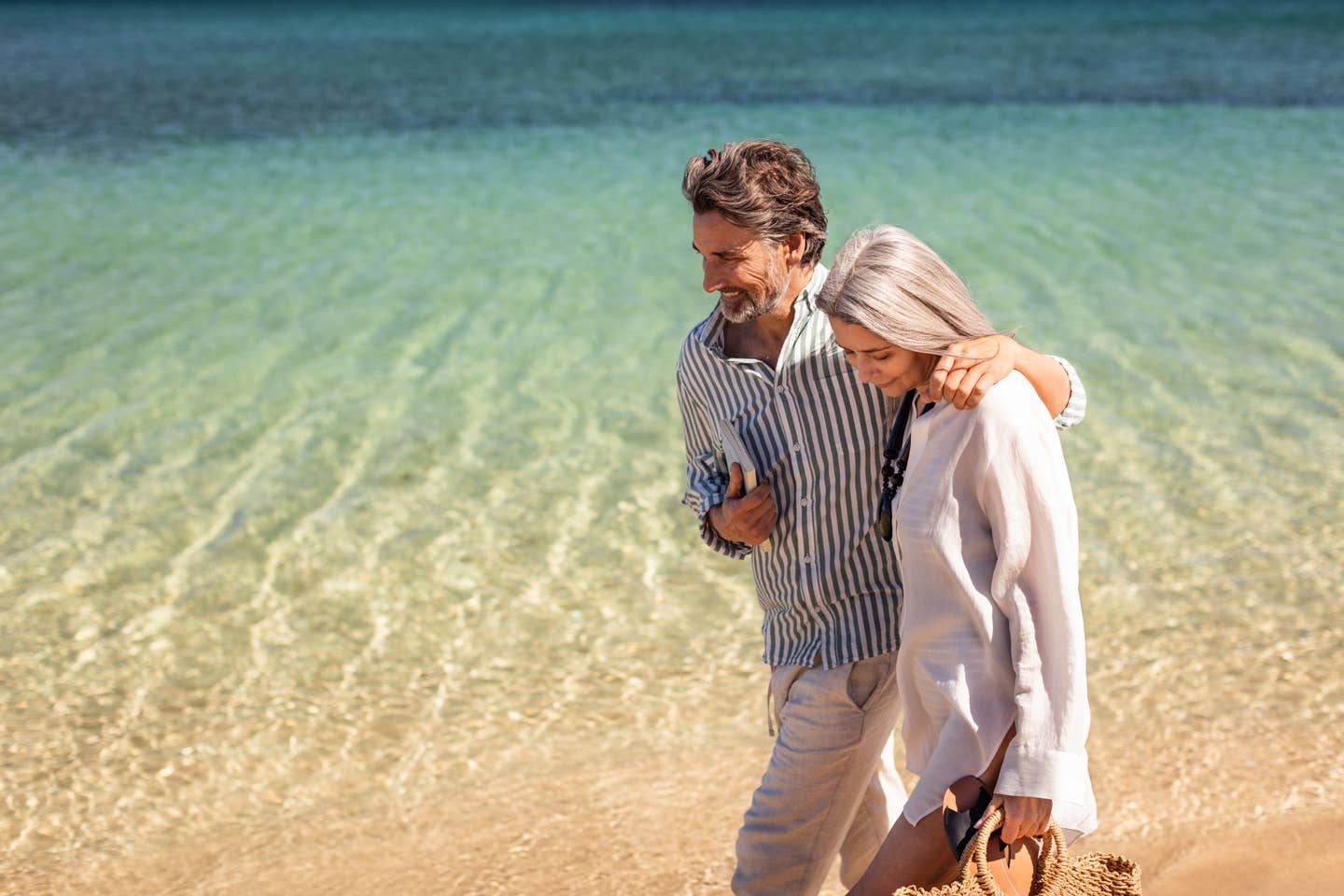 Paar, das Arm in Arm am Strand läuft Paar, das Arm in Arm am Strand läuft