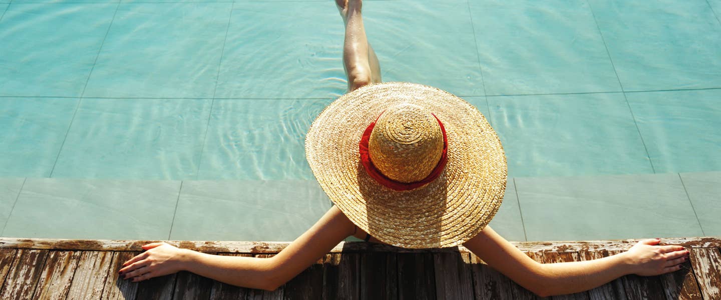 Frau die am Poolrand sitzt und entspannt Frau die am Poolrand sitzt und entspannt