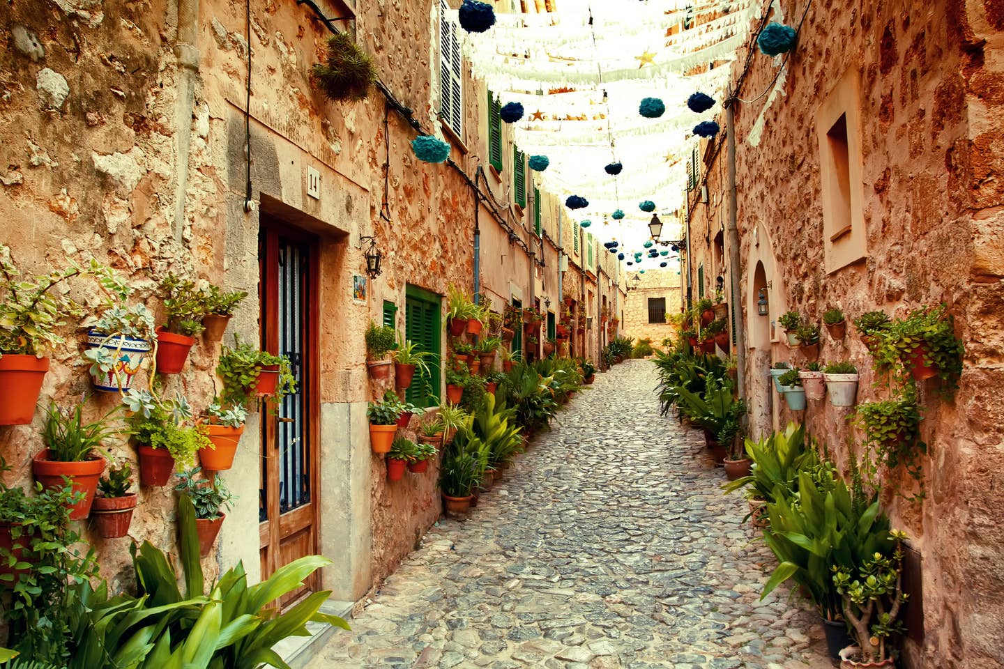 Ruelle en Espagne avec de nombreux petits pots de plantes