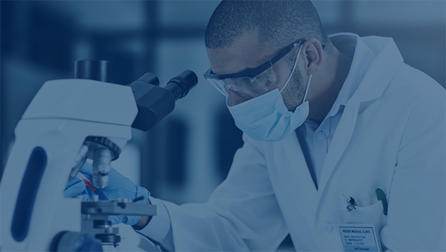 Man sieht eine medizinische Fachperson, die mit einem Mikroskop etwas untersucht.