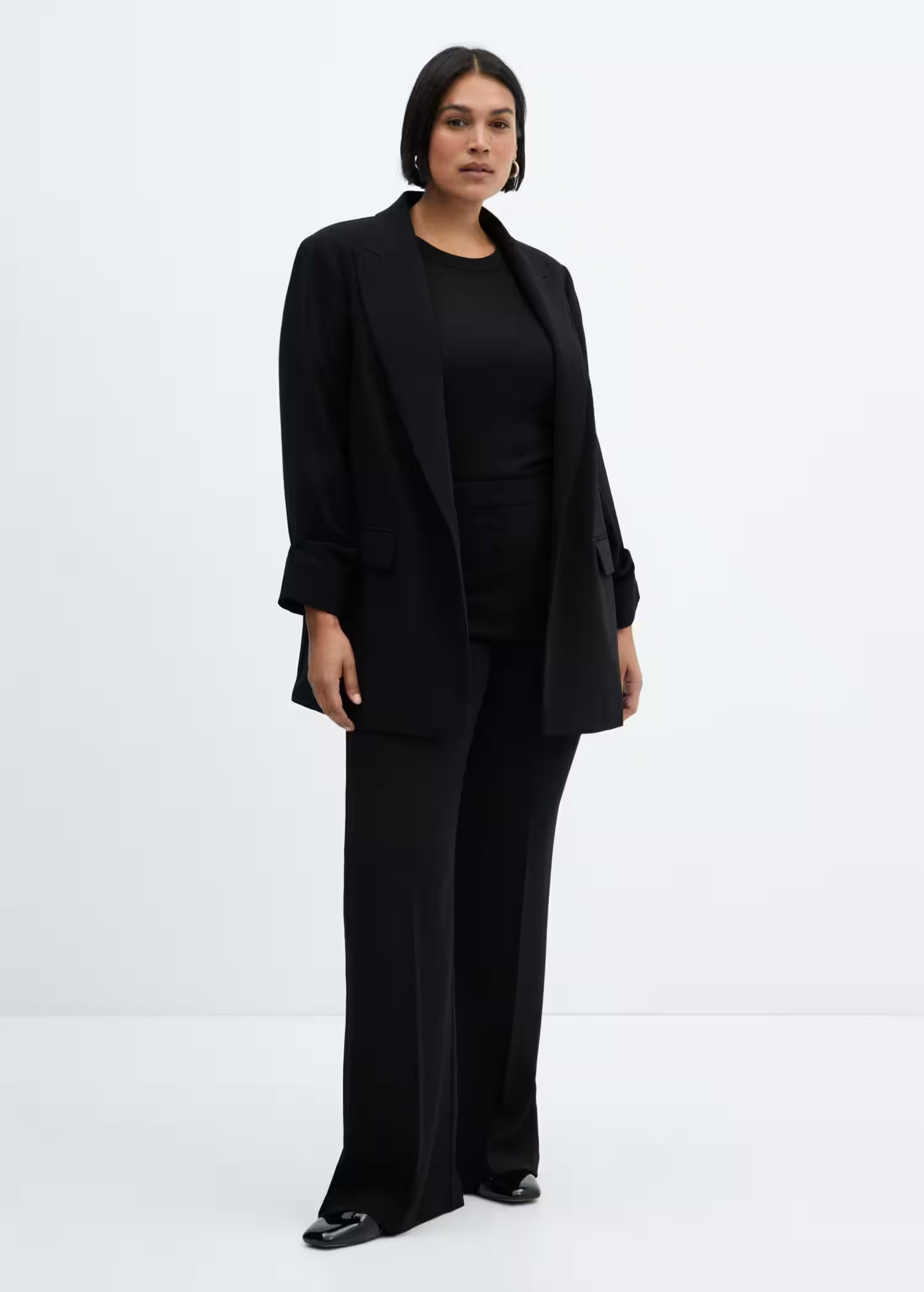 Mujer llevando un traje de chaqueta negro de estilo minimalista