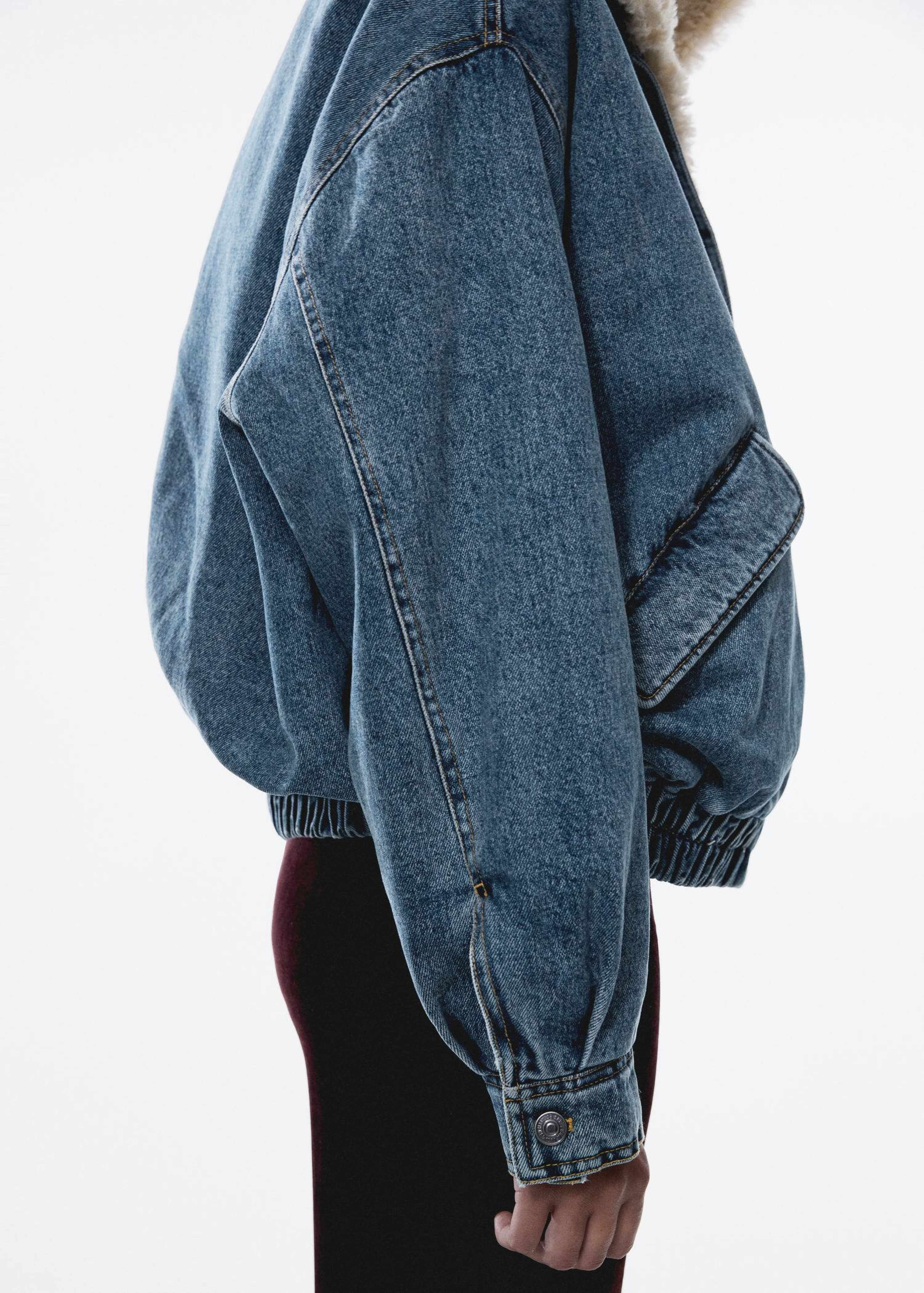 A girl wearing a woman's denim outfit with a bomber jacket.