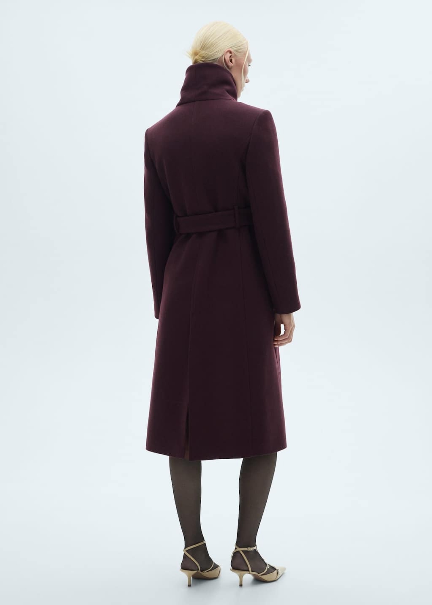 Woman wearing a coat in autumn colours such as purple.