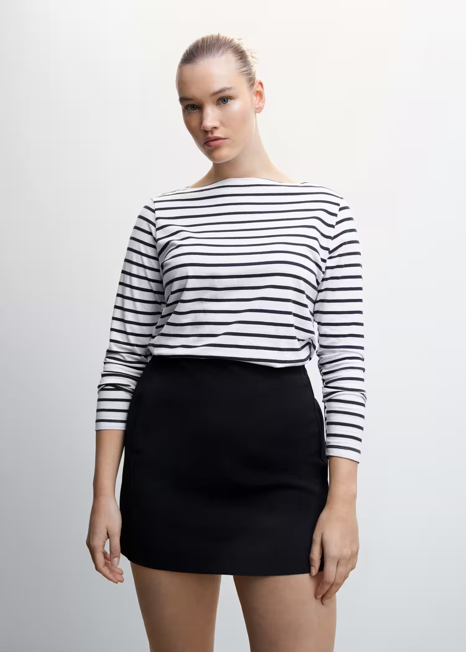 Girl wearing a Parisian outfit with a striped T-shirt and a black skirt.