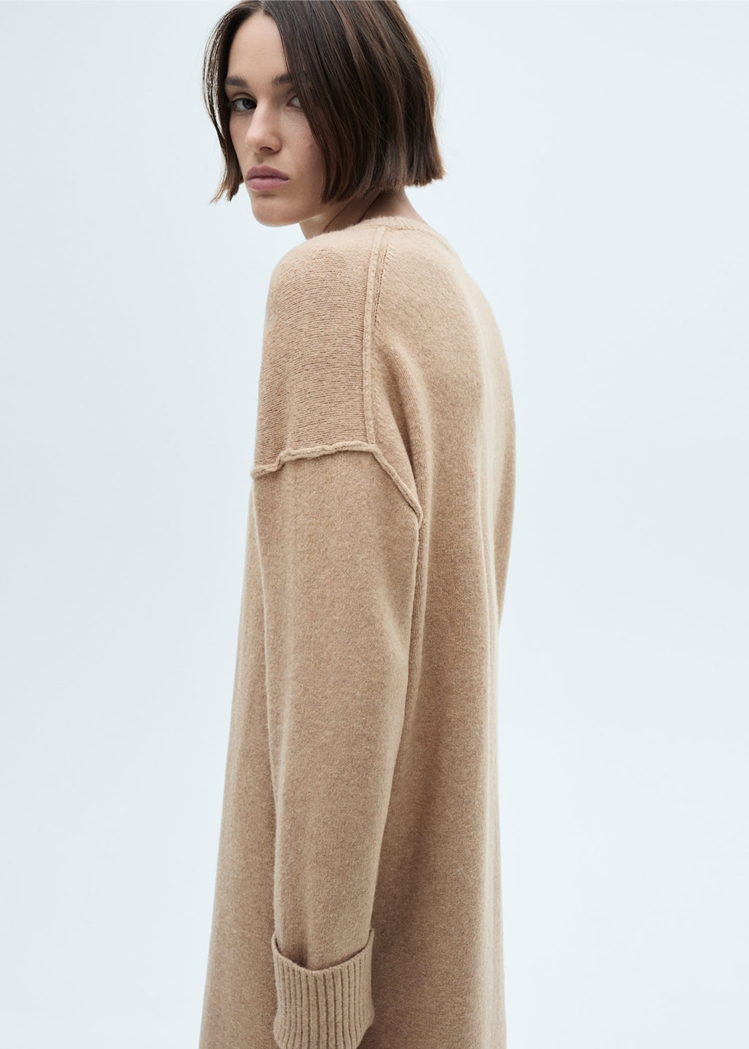 Donna che indossa un look casual con abito lungo in maglia.