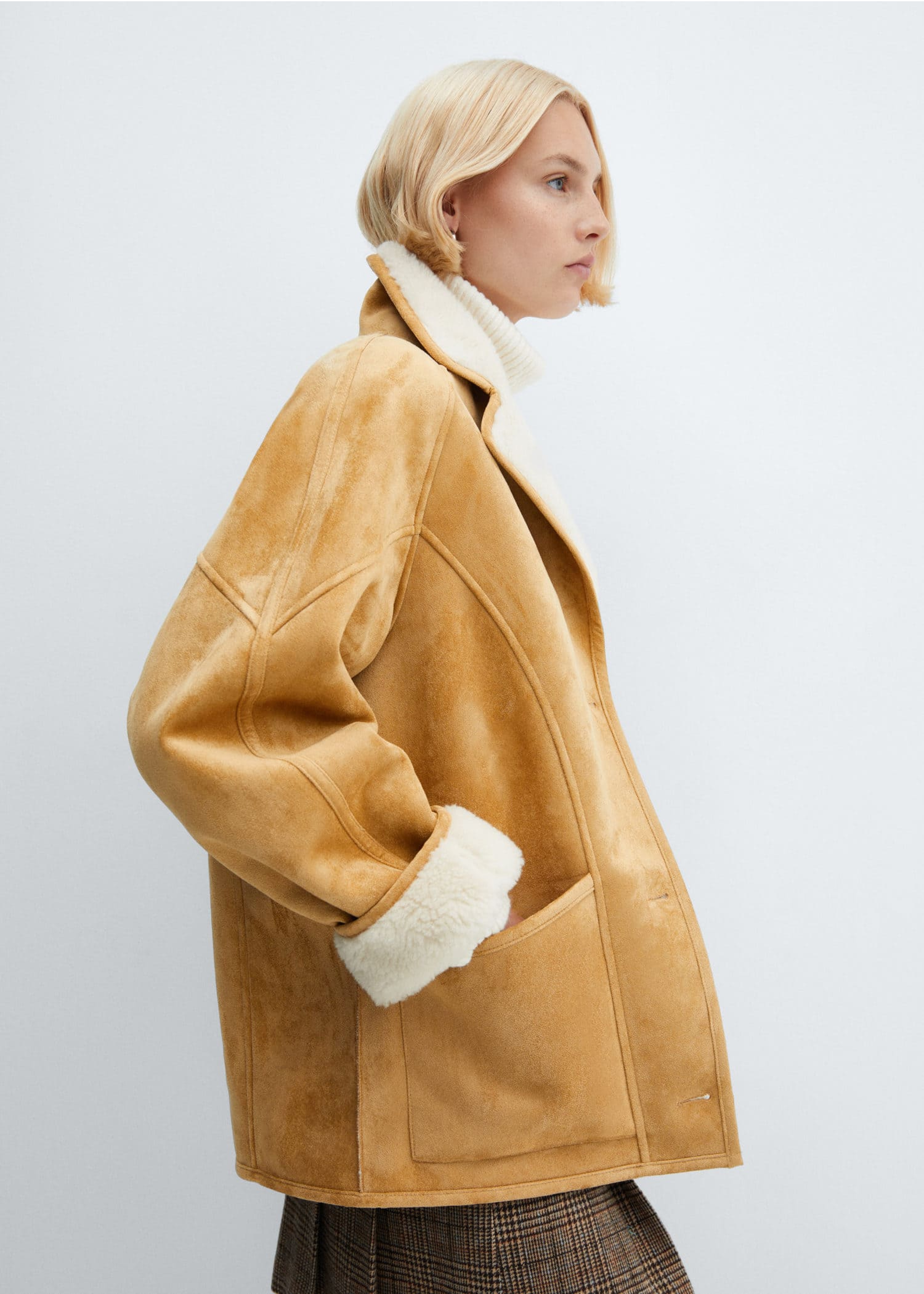 Mujer usando un abrigo oversize color camel con pelo blanco