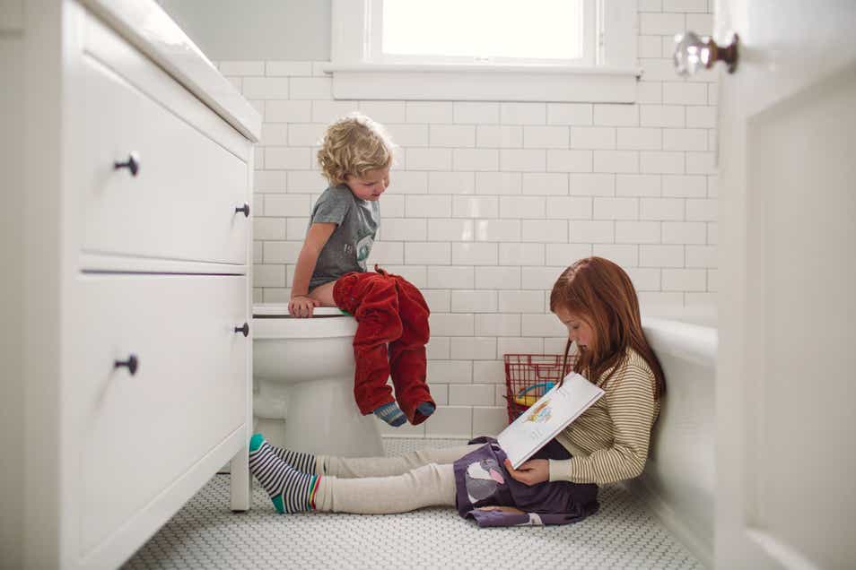 two children playing on a bathroom floor