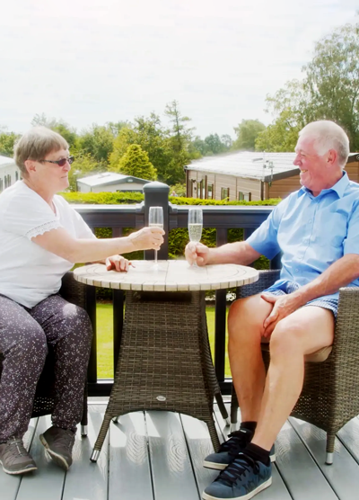 A couple drinking champagne on their holiday home decking