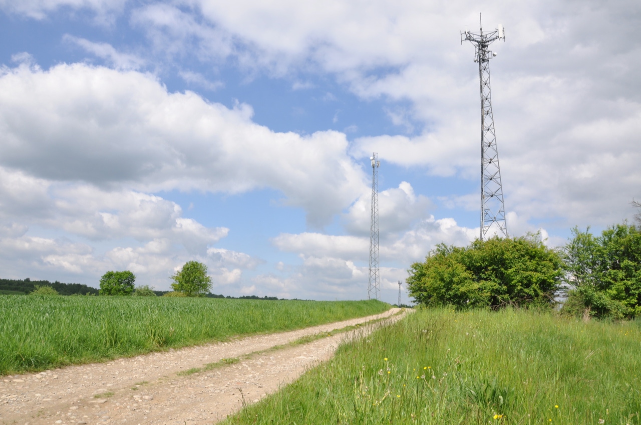 Telecommunication tower on the field against the sky