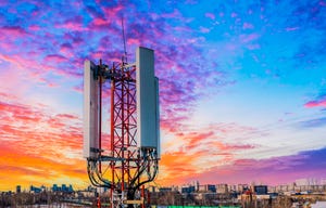 Mobile telephone mast against orange sunset background.
