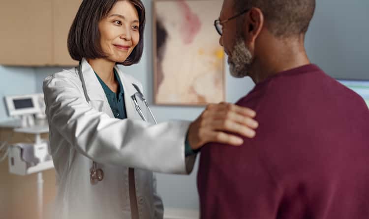 Leben mit dem Multiplen Myelom Bild zum Thema Multiples Myelom: Ärztin legt einem Patienten beruhigend die Hand auf die Schulter während eines Gesprächs.