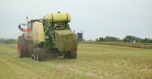 Tractor in field fertilizing pasture and hay ground 