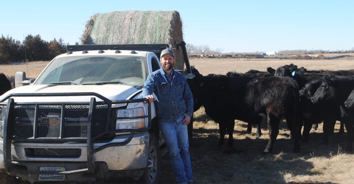 Mark Miles next to pickup truck with cattle in the background