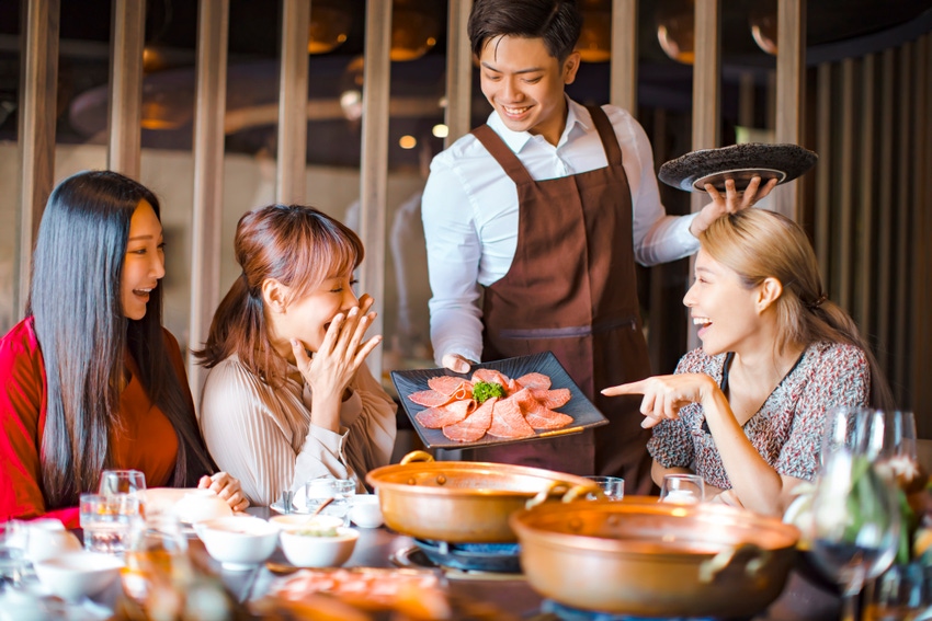 A group of consumers eating beef A group of consumers eating beef