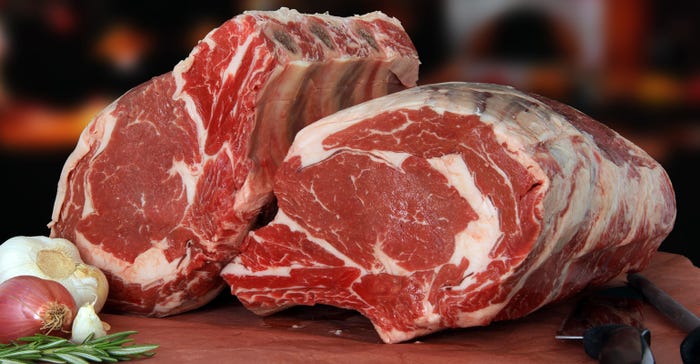 raw prime rib beef roast on cutting board