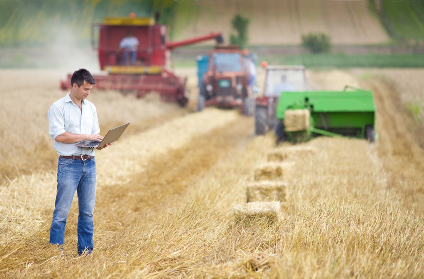 farmer on laptop in field during harvest_FDS_Jevtic_iStock_Getty Images-512008841.jpg
