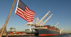 American flag waves in the foreground at U.S. port