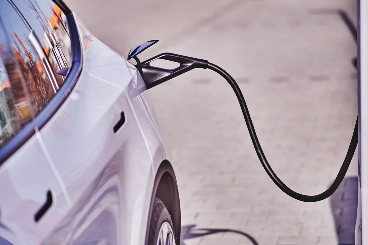 White car plugged in to an EV charger White car plugged in to an EV charger