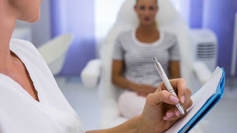 Farmacéutico de hospital dispensando medicamentos a una paciente de artritis psoriásica