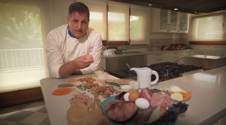 Cocinero explicando que alimentos proporcionan proteinas y carbohidratos.