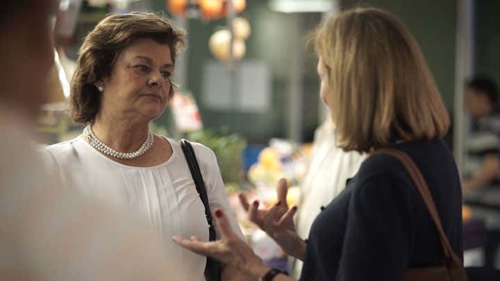 Nutricionista asesorando en un mercado en un puesto de frutas y verduras