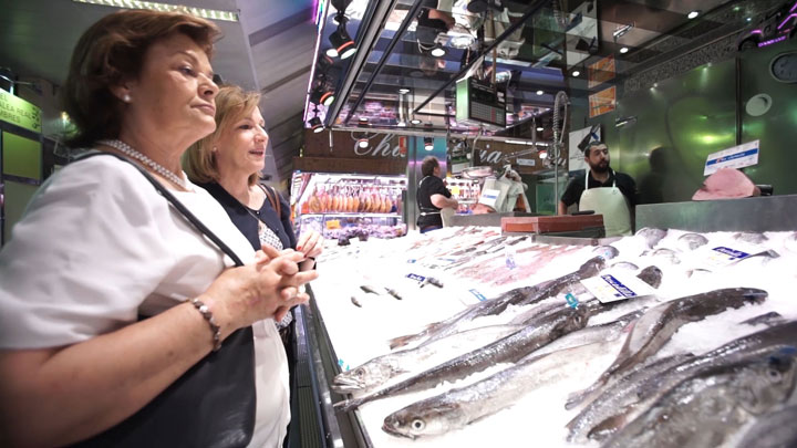 Nutricionista asesorando en un mercado en un puesto de pescado