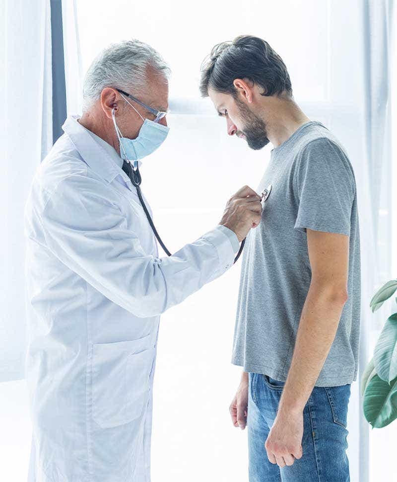 Doctor auscultando al un paciente para detectar posibles tumores torácicos.