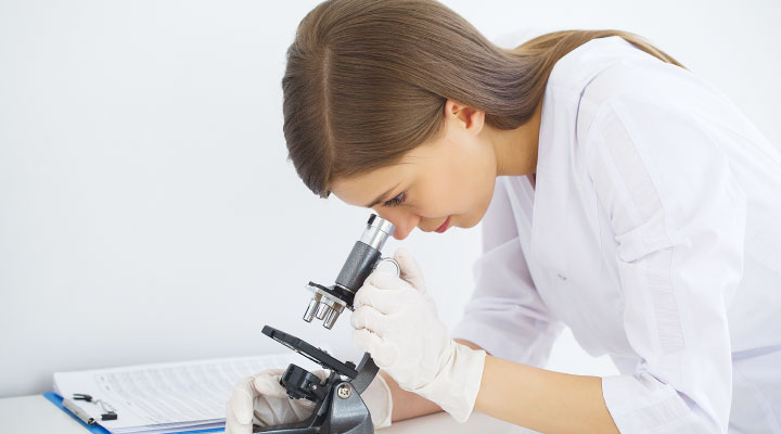 Farmacia de hospital mieloma múltiple: profesional sanitario con un microscopio.