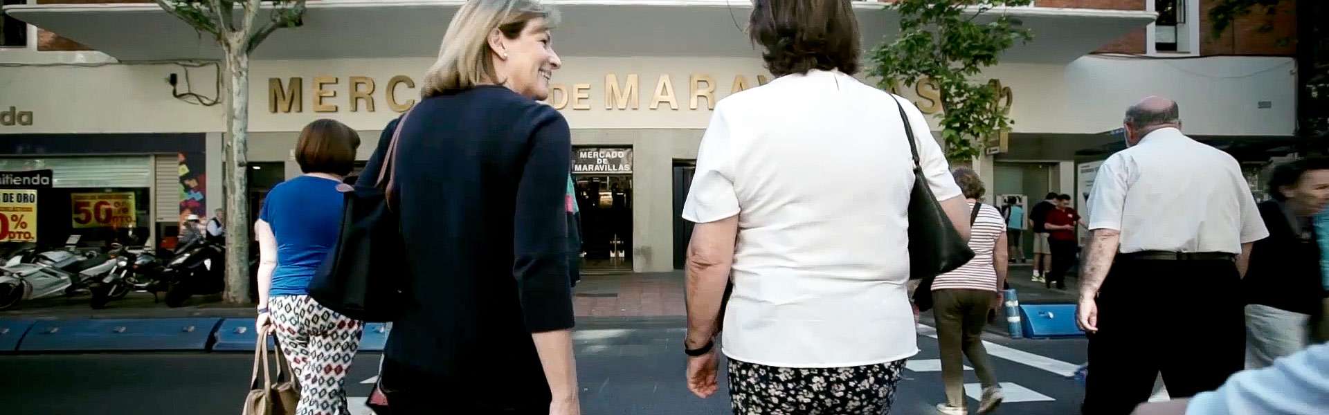 MQA-Al mercado con mi asesora Asesora con una mujer en la entrada de un mercado