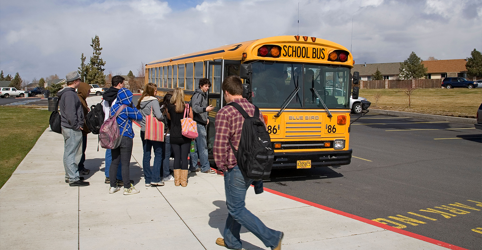 Kids getting on a school bus.