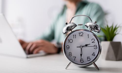 Raisin ES- reloj despertador metálico junto a portátil