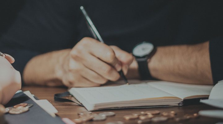 Raisin UK-Person writing in notebook