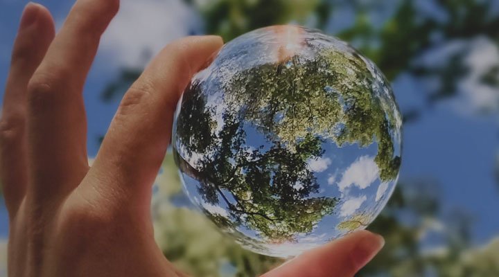 Raisin UK-Hand holding reflective glass orb