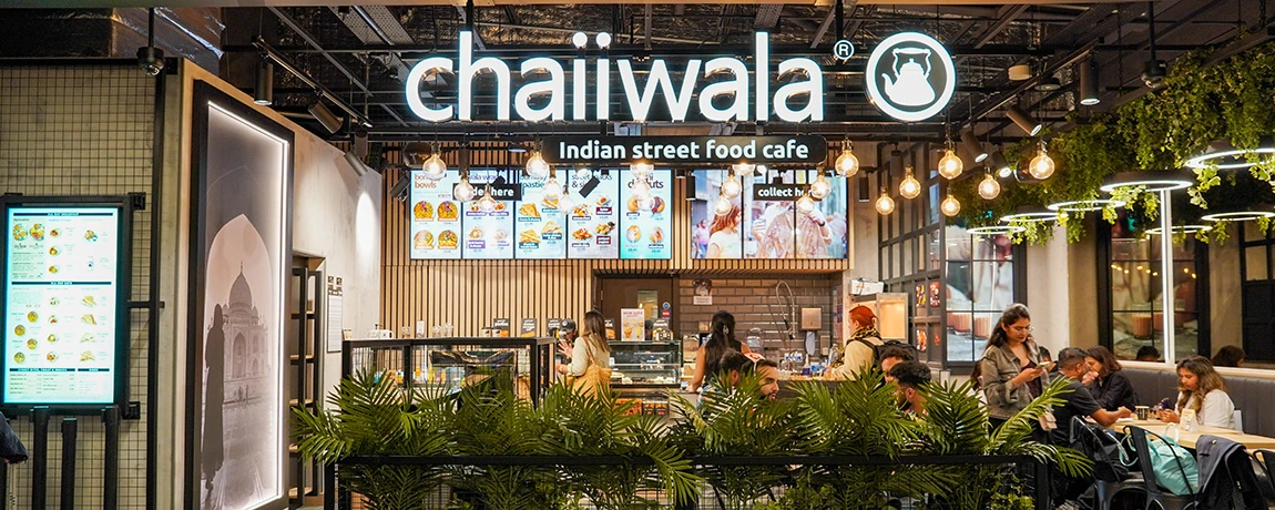 People sit in Chaiiwala at London Luton Airport