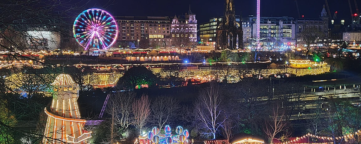 Christmas market with stalls and big wheel in Edinburgh, Scotland