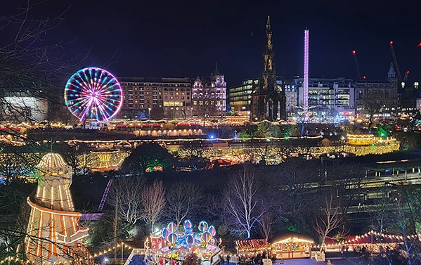 Marekt stalls, big wheel, christmas lights and tree showcasing Edinburghs, Scotland Christmas markets.