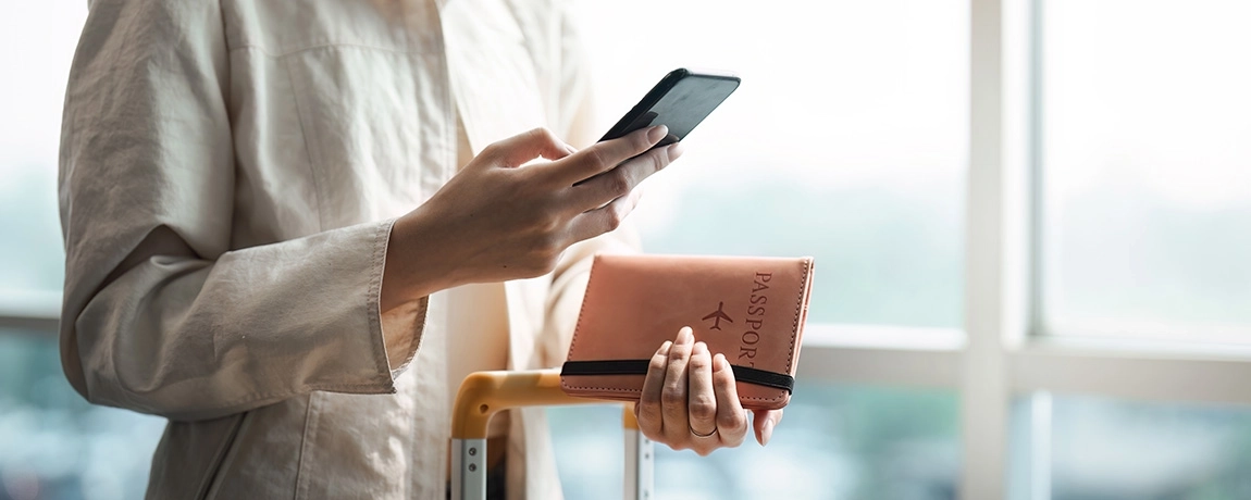 lady on mobile phone holding passport.webp