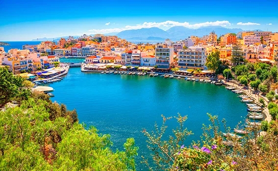 Harbour with colourful buildings and clear blue skies in Crete, Greece.