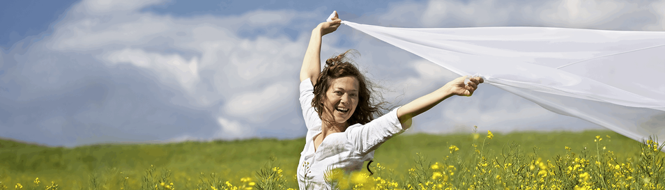 Donna con lenzuolo bianco in un campo di fiori