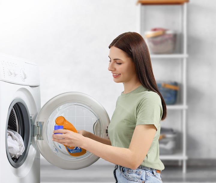 Sole Bianco Splendente viene versato nel cassetto lavatrice da una donna