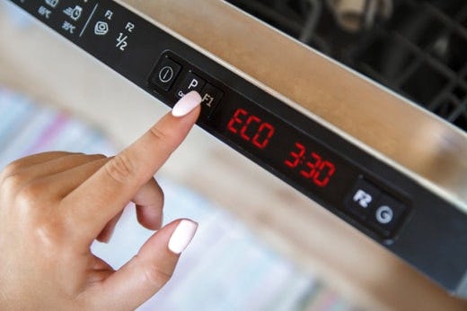 Mano presionando botones de lavavajillas