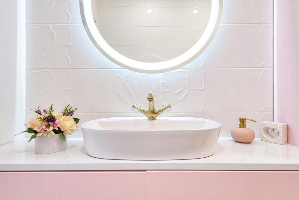a white bathroom sink with golden color faucets