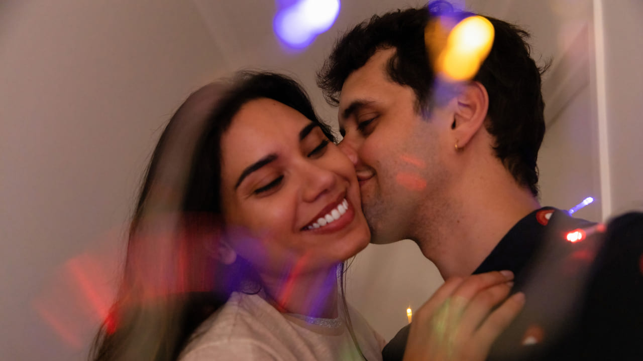 Hombre a punto de besar a una mujer tomandola de la cara