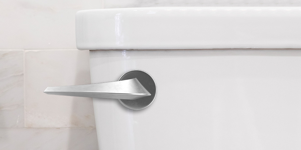 Close-up of a white toilet tank with a silver handle.