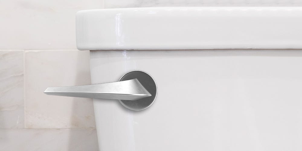 Close-up of a white toilet tank with a silver handle.