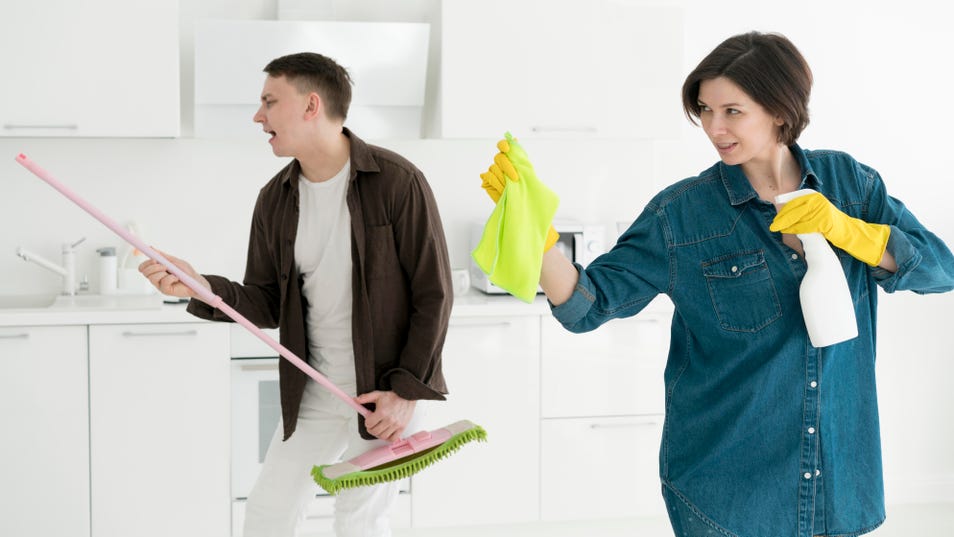 a man holding the mop and a woman holding cloth and commercial cleaner bottle