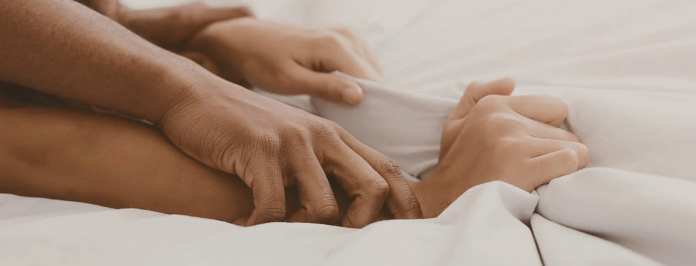 Endurance collection - couple holding hands in bed banner