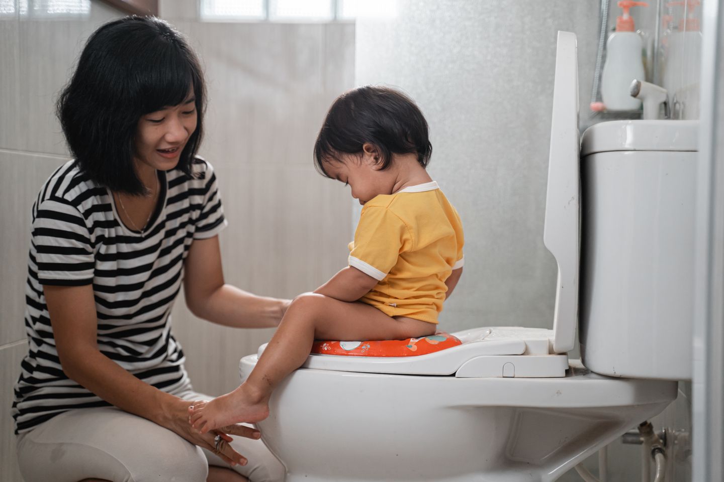 a baby sitting on potty training seat