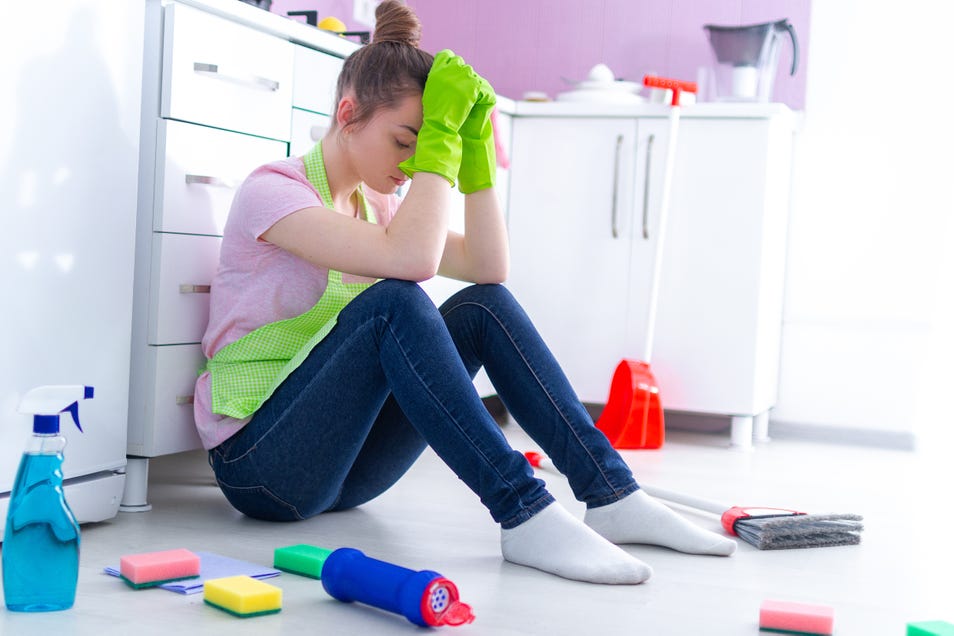 A woman feeling fatigue after a long day of house cleaning