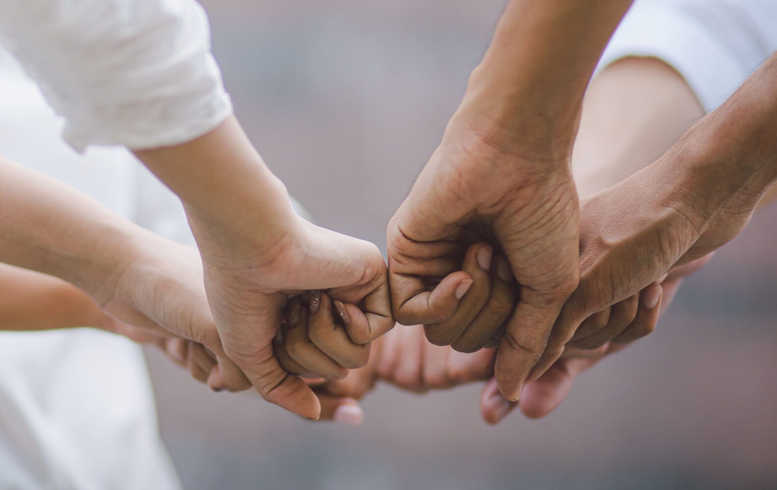 Varias manos juntando sus puños